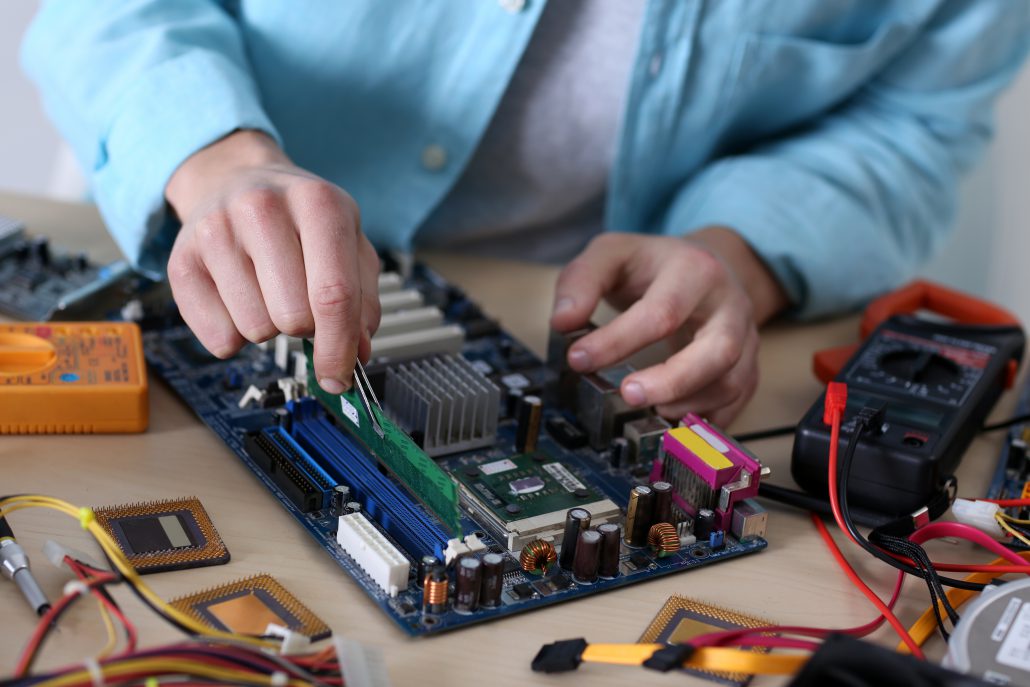 Young man repairing computer hardware in service center TechLink